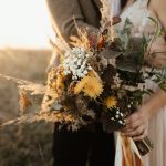 Beautiful bouquet of wild flowers in the hands of the bride